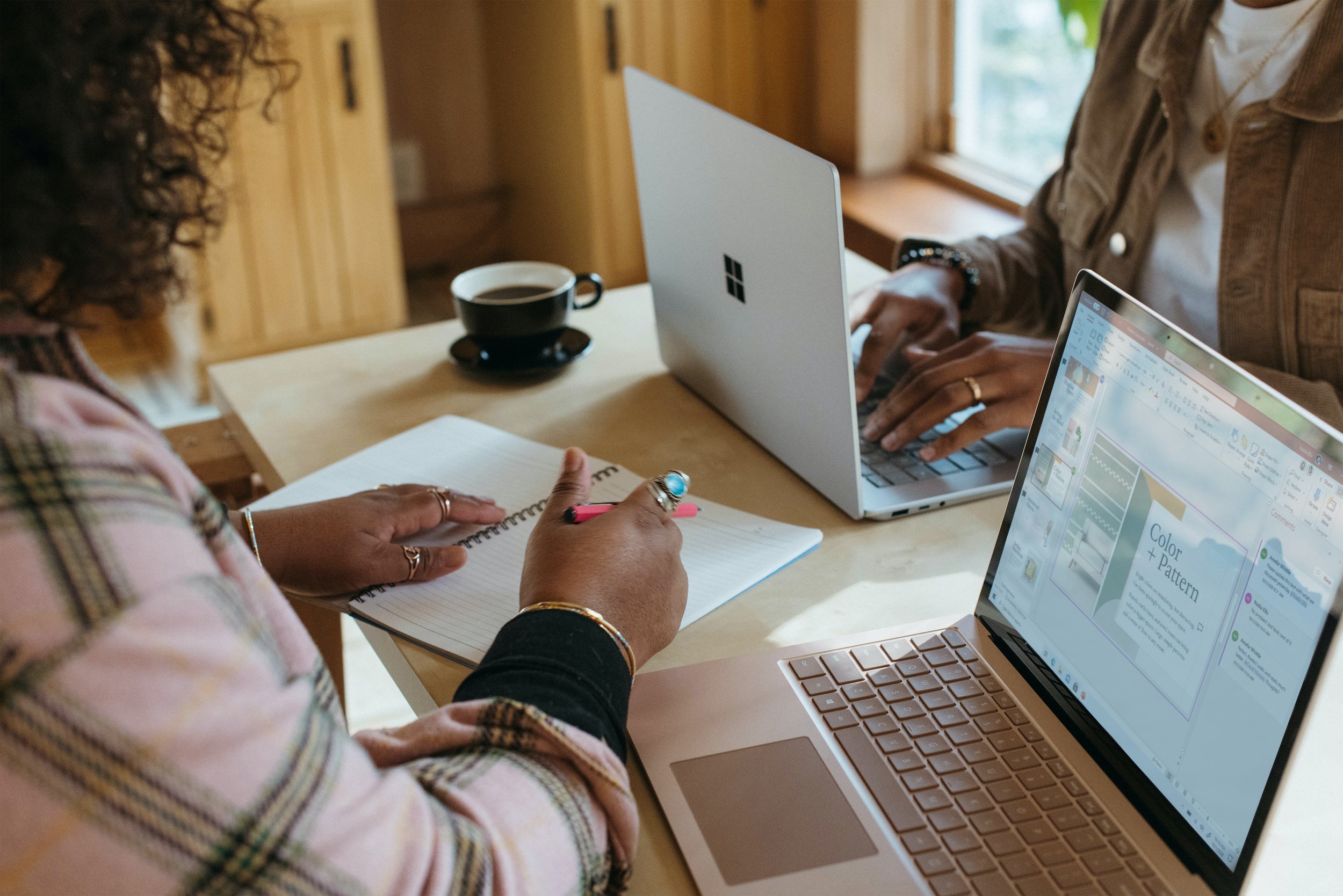 Photos of two Black people at laptops in a coffee shop. One person is writing in a notebook and the other has a cup of coffee.