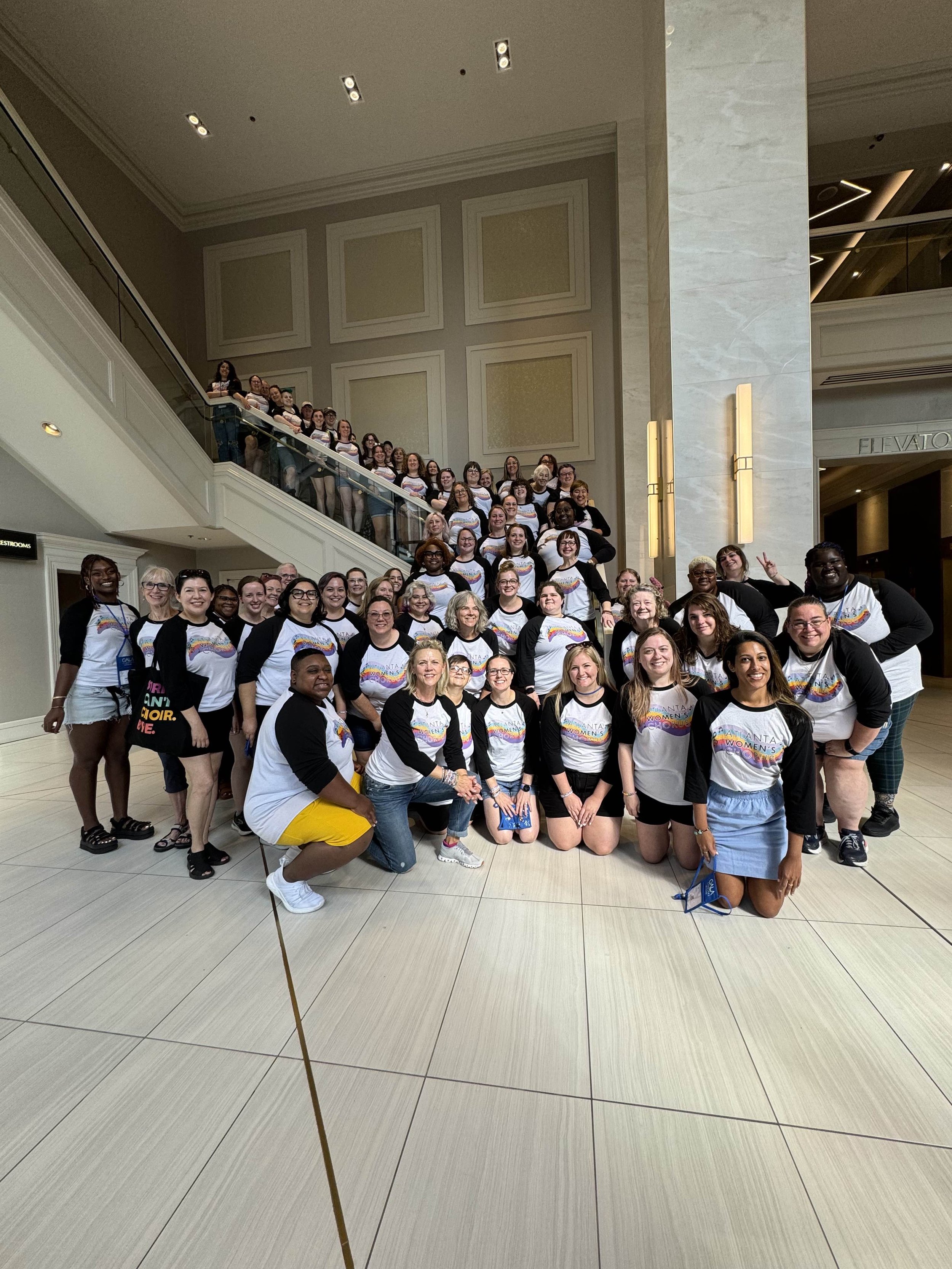 A photo of the Atlanta Women's Chorus posing on a stairwell