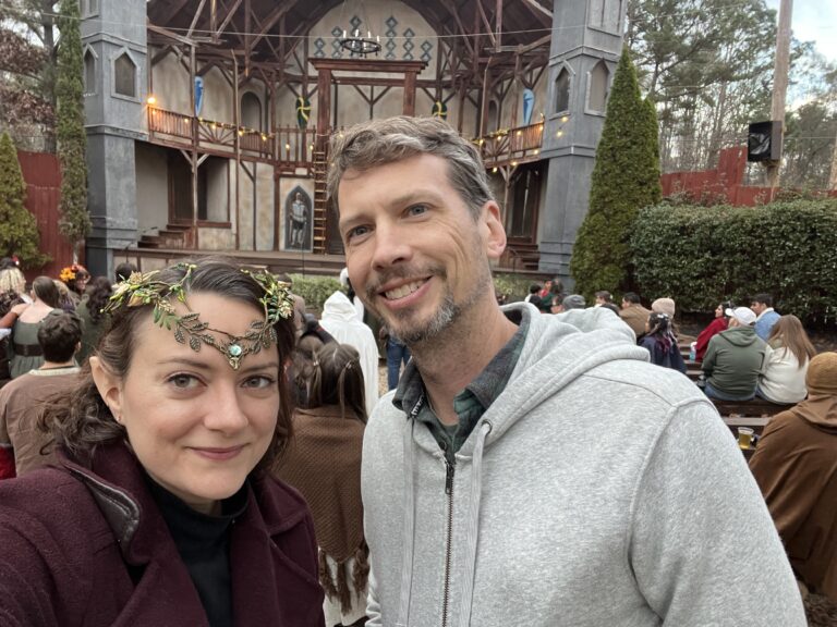 The author is pictured at a Renaissance Festival wearing elf ears and a fairy crown.